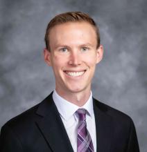 man smiling in front of grey background