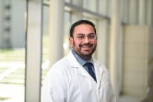 man with dark hair and glasses on smiling