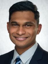man in business attire with dark hair smiling