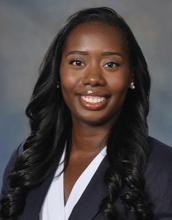 woman with long, curled dark hair smiling
