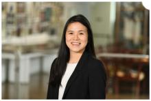 woman in a blazer, with dark hair smiling