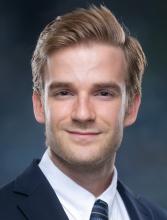 man with blonde hair in a suit smiling