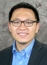 man smiling in front of grey background