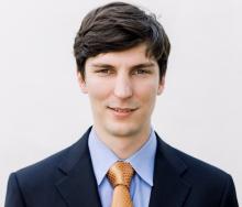 man with short dark brown hair smilling