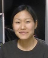 woman with her hair tied back smiling lightly