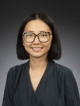 Woman smiling in front of grey background