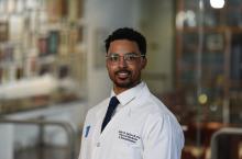 man with short dark hair and glasses on smiling