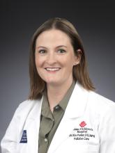 Woman smiling in front of grey background