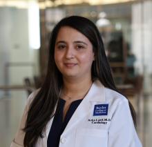 woman with long dark hair smiling lightly