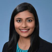 photo of a woman smiling in front of a blue background