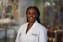 woman with her hair in a half-up/half-down hairstyle smiling