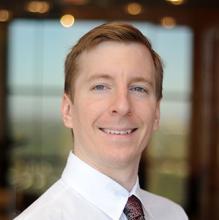 Man smiling in front of a building