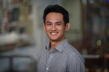 man in a button down with dark hair smiling