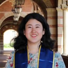 person with medium length, black hair smiling