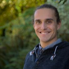 man in a blue sweater smiling