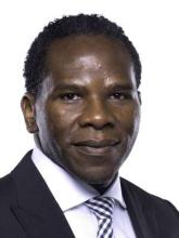 man in a suit and checkered tie smiling