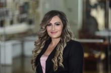 woman with long curled hair smiling
