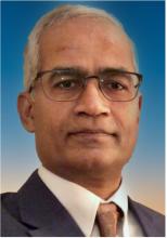 man in a suit with glasses on smiling