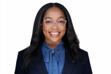 woman with long dark hair and clear glasses on smiling