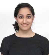 woman in a black tshirt with her hair tied back, smiling