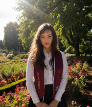 woman with long brown hair smiling in a garden