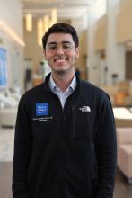 man with dark hair and glasses on smiling