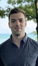 man smiling lightly outside