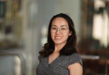 female smiling with dark hair wearing glasses and blouse