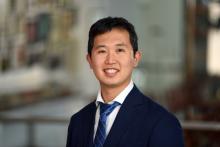 male with dark hair smiling wearing suit