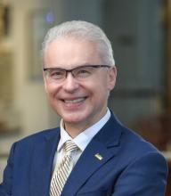 Jakub Tolar wearing a blue suit and smiling