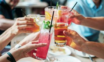 Group of people holds glasses of various alcoholic beverages