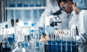 Scientists working in a lab filled with containers of blue liquid