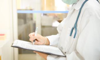 Photo of doctor writing on pad