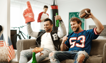 Football fans cheering in their living room. 
