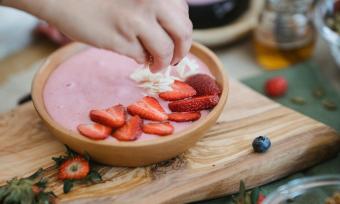 Photo of strawberry yogurt with chopped strawberries and other fruit.
