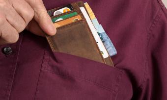 A close up photo of a man's front pocket with a bill fold holding credit cards to represent shopping addiction.