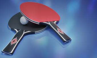 Photo of a ping pong paddle laying on top of a ping pong ball.