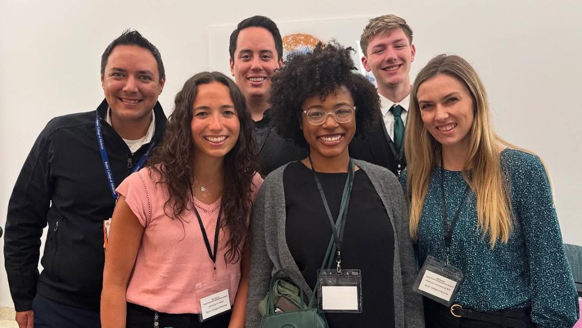group of people standing in front of a white background