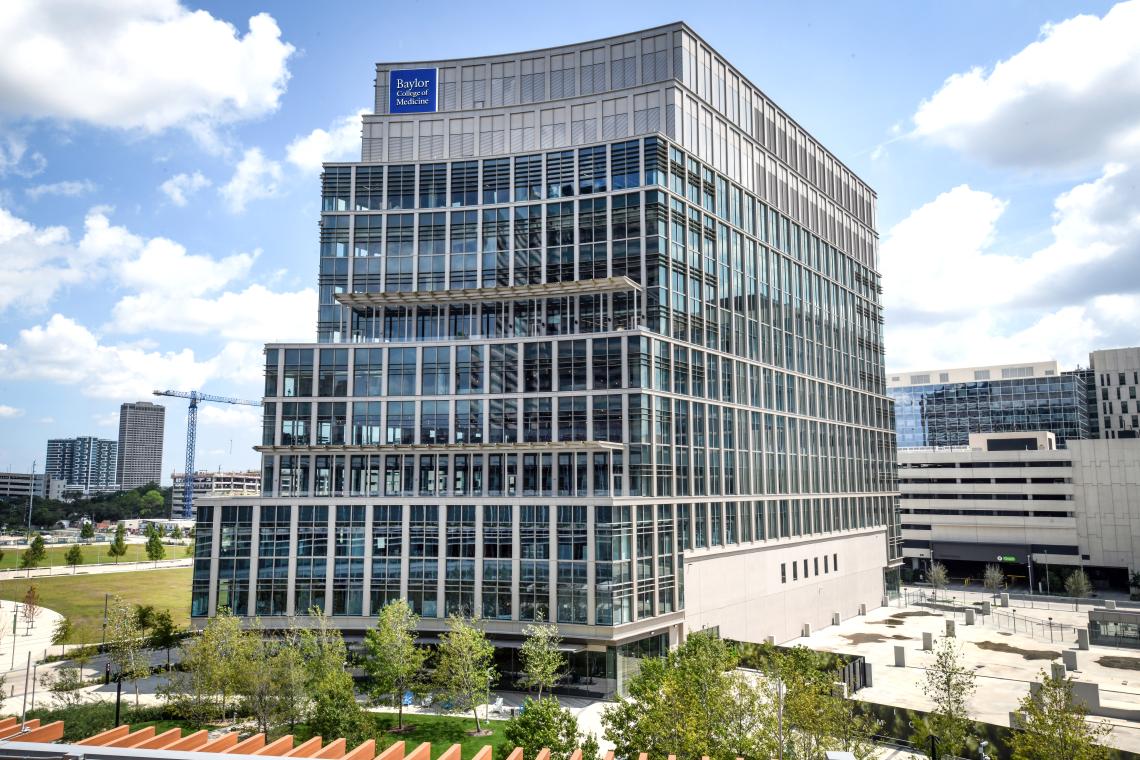 photo of a modern silver building with with a few trees around it