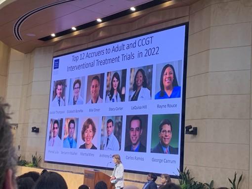 person speaking in front of a large powerpoint presentation screen