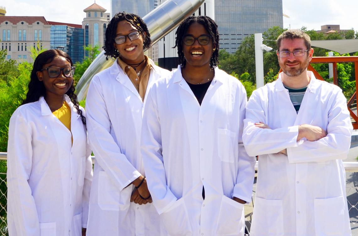 group of 5 people in white coats standing outside