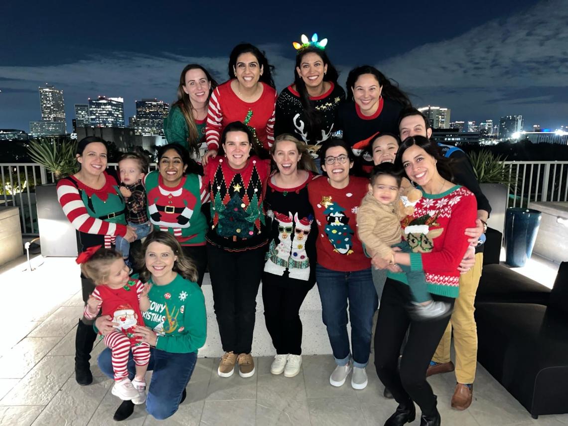 group of people in christmas sweaters smiling