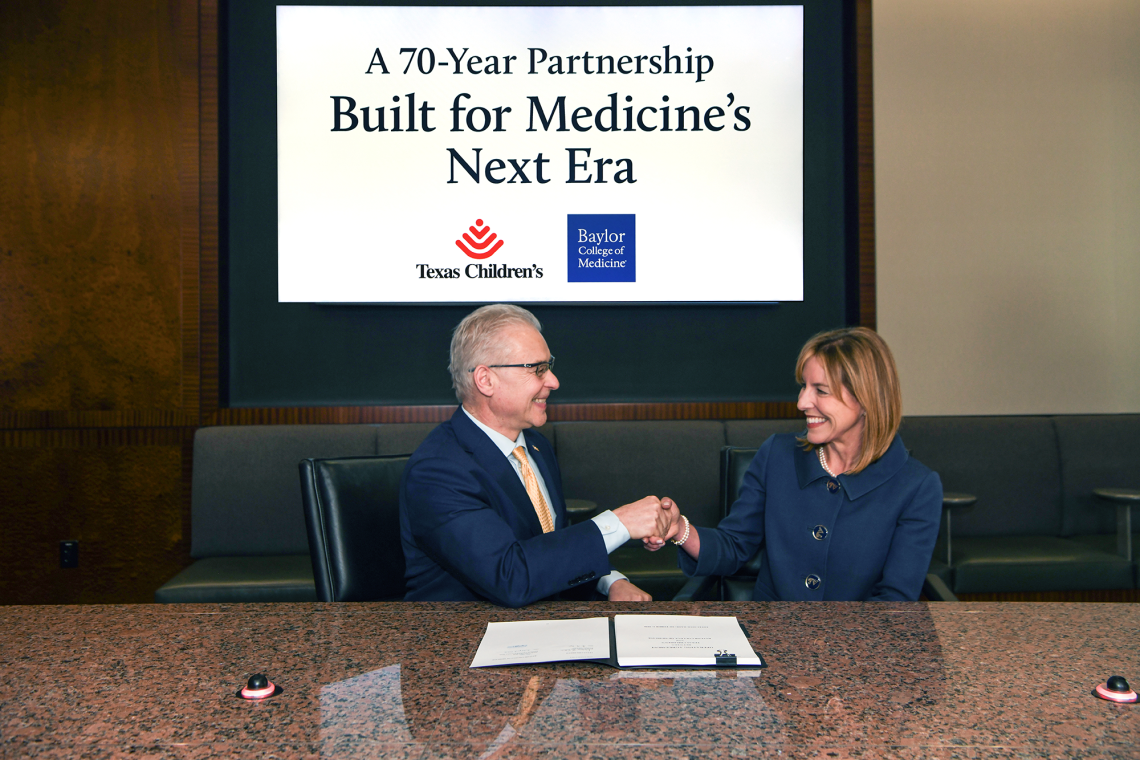 Dr. Jakub Tolar and Dr. Debra Sukin shaking hands while signing the agreement