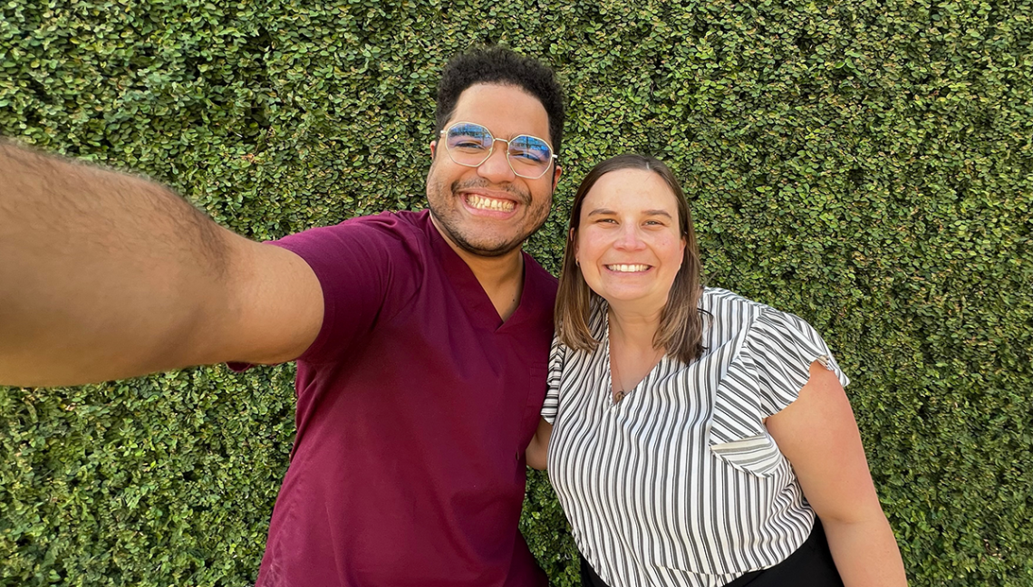 Cesar Larancuent and Kristiana Morgan taking a selfie in front of shrubbery 