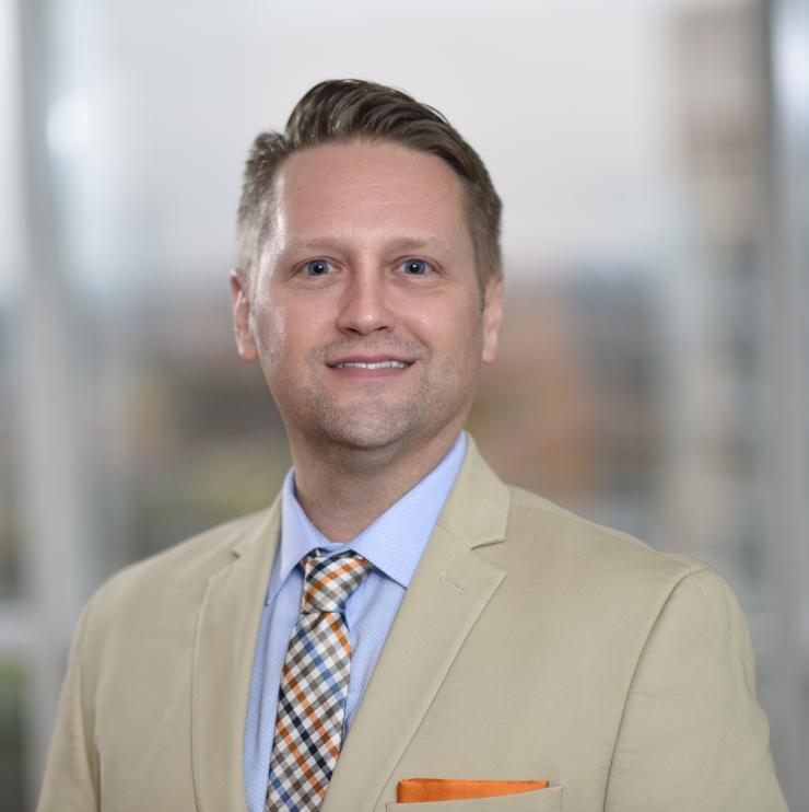 Man smiling in front of city backdrop