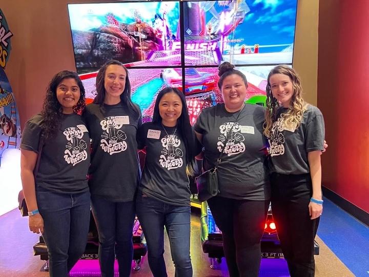 five woman in matching shirts smiling