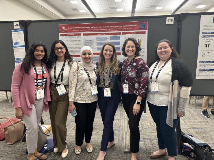 group of people standing in front of academic posters