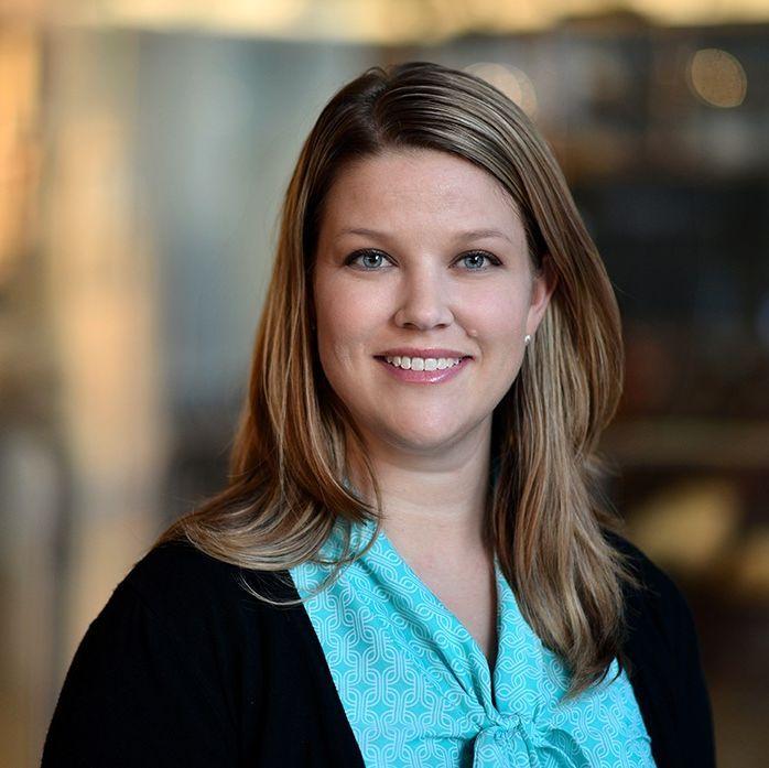 woman in a light blue top with medium length hair smiling