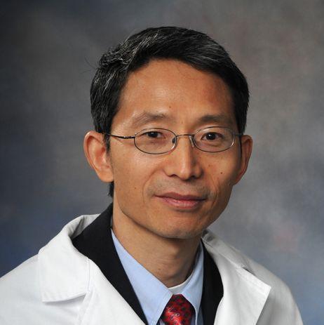 man smiling in front of grey background