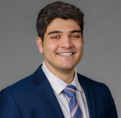 Man smiling in front of grey background
